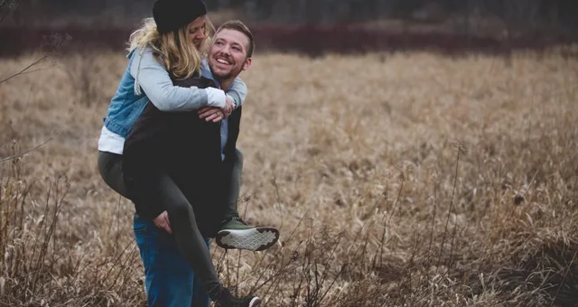 žena na zádech muže na podzimní louce